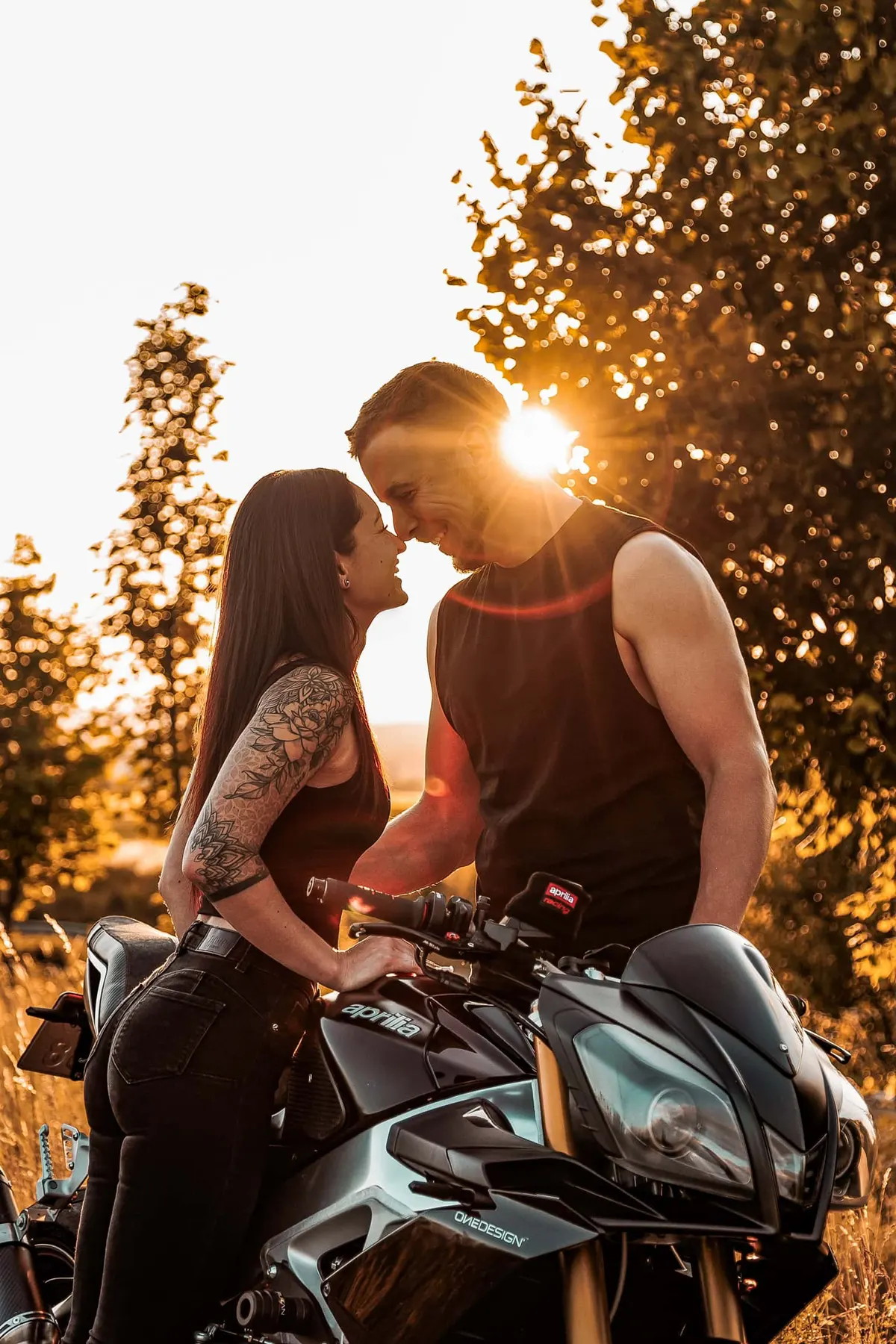 Pár na motorce při západu slunce